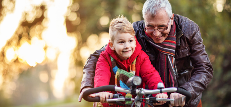 Grandfather teaching grandson to ride a bike