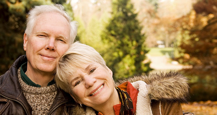 middle-aged couple sitting together on a park bench